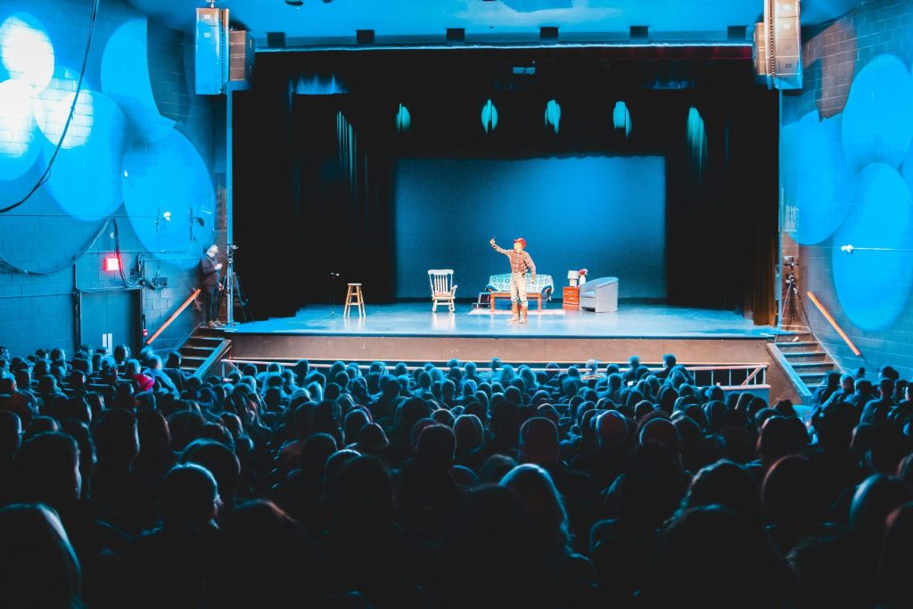 people standing on stage with lights turned on during nighttime